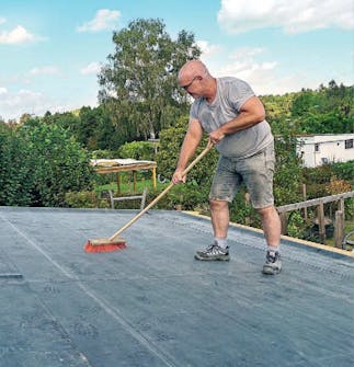Isoleret anneks: Gummidug lægges over klæber på taget af isoleret anneks Isoleret anneks: Gummidugen lægges over klæberen på taget af isoleret anneks